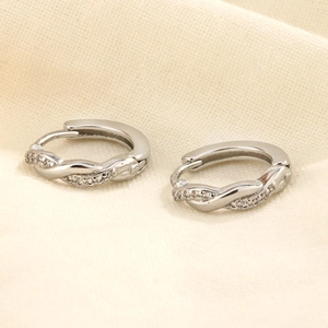 Détail de boucles d'oreilles Mobius argentées avec incrustation de zircone cubique