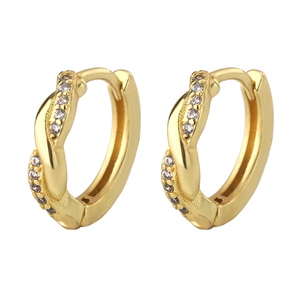 Gros plan de boucles d'oreilles Mobius dorées avec zircons sur fond blanc pur