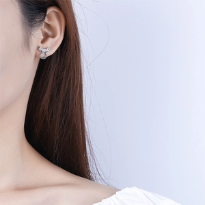 Close-up of elegant silver gourd stud earrings with inlaid zircon on female model