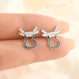 Detail of silver reindeer antler stud earrings with green enamel and white zircon stones