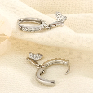 Détail de boucles d'oreilles créoles papillon en argent avec incrustation de zircons