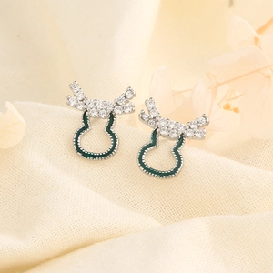 Close-up of reindeer antler stud earrings with green enamel and sparkling crystals