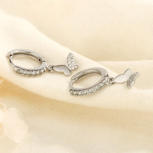 Détail macro de boucles d'oreilles papillon en argent avec zircons et fini poli