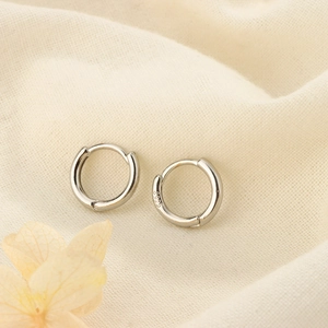 Macro shot of minimalist S925 sterling silver hoop earrings with clear S925 hallmark