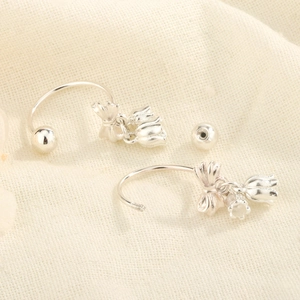 Boucles d'oreilles muguet avec nœud et fermoir à vis sur tissu beige doux