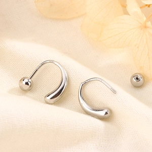 Dettaglio di orecchini a U in argento sterling S925 con sfera in metallo lucido