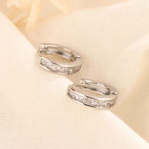 Detailed macro of silver s925 hoop earrings with channel-set cubic zirconia crystals