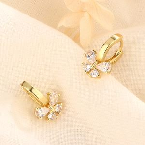 Close-up of S925 sterling silver bow earrings with sparkling zircons on fabric