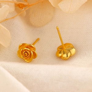 Détail macro de boucles d'oreilles rose dorée montrant le poinçon S925 sur métal mat