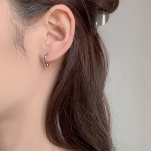 Orecchini minimalisti a goccia in argento con sfera lucida indossati dalla modella