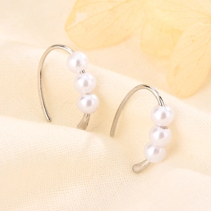 Elegant silver hook earrings featuring three linear pearls on a soft fabric background