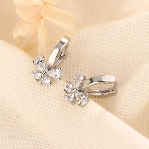 Elegant S925 silver bow earrings with sparkling cubic zirconia on soft textured fabric