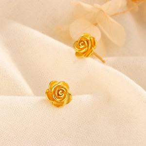 Boucles d'oreilles vintage en forme de rose dorée avec pétales texturés sur du lin