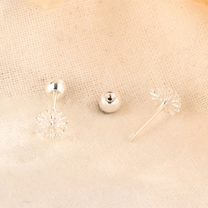 Vue détaillée des boucles d'oreilles pissenlit en argent avec fermoir à vis sur tissu