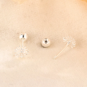 Paire de boucles d'oreilles pissenlit en argent avec fermoir à vis sur tissu beige