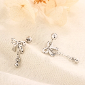 Macro view of silver bow earrings with tassel chain and screw back closure detail