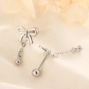 Detailed shot of silver bow earrings with chain tassels and secure screw-back closure