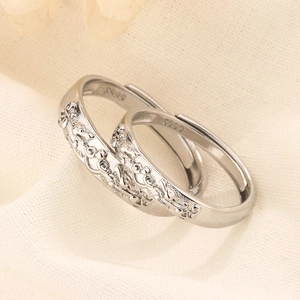 Vue rapprochée des bagues de couple en argent S999 avec relief floral et design
