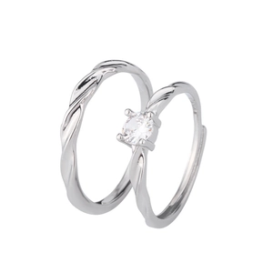Macro detail of silver Mobius couple rings with twisted texture and round solitaire stone