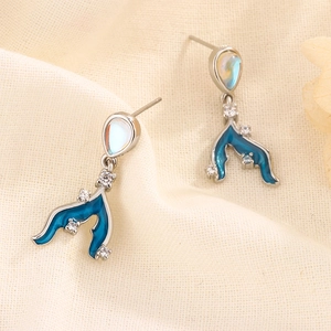Detail of S925 silver mermaid tail earrings with blue enamel and moonstone inlay