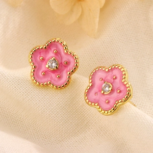 Close-up of pink enamel peach blossom stud earrings with gold plating and cubic zirconia