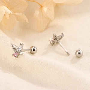 Macro shot of silver butterfly stud earrings with pink zircon and screw ball backings