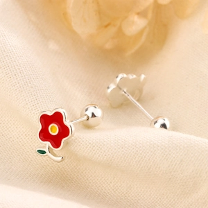 Détail de boucles d'oreilles fleur rouge avec fermoir à vis sur tissu blanc