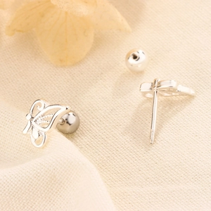 Macro shot of silver hollow butterfly stud earrings with secure screw ball back closure