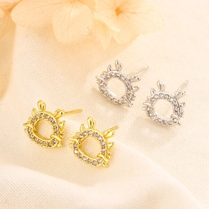 Detail view of sparkling gold and silver dragon horn stud earrings with micro-set zircons