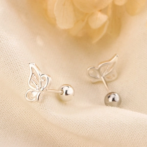 Hollow butterfly screw back earrings in sterling silver on a textured fabric background