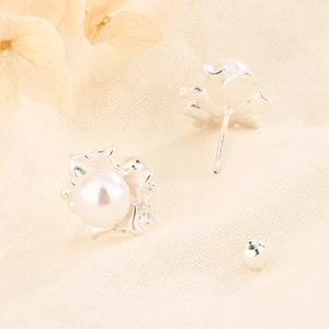 Macro view of flower pearl earrings featuring screw back design and detailed silver petals