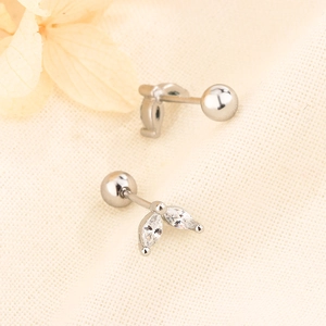 Macro detail of silver leaf cartilage earrings with marquise zircon and ball screw back