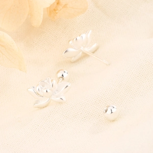 Elegant silver lotus stud earrings with screw-back design on beige textured fabric