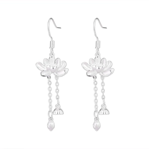 Détail de boucles d'oreilles lotus en argent avec pompons et breloques délicates
