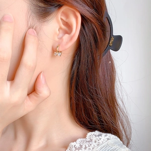 Boucles d'oreilles nœud vintage français avec dorure et zircons portées par un mannequin