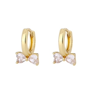 Boucles d'oreilles nœud dorées avec cristaux de zircone en cœur sur fond blanc épuré