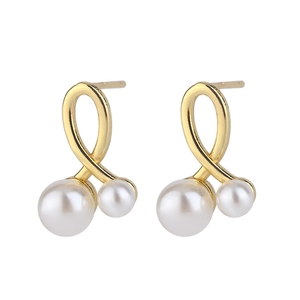 Detail of gold-plated twisted cross earrings with layered white pearls on white background