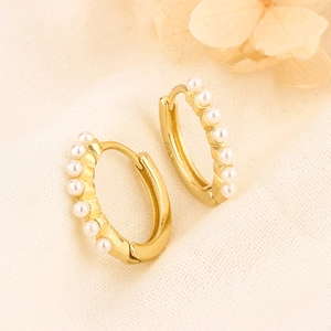 Elegant gold S925 silver hoop earrings with seven inlaid white pearls on cream fabric