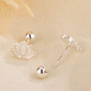 Macro shot of S925 sterling silver lotus stud earrings with screw backs on cream fabric