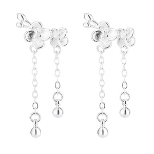 Detail of silver plum blossom tassel earrings with layered petals and polished metal balls