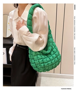 Detail of bright green quilted puffy tote bag with soft texture and matching strap