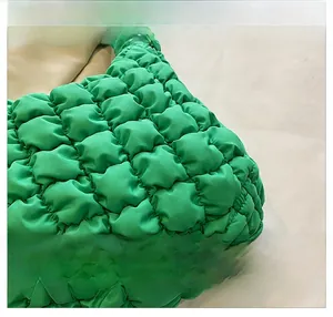 Close-up of bright green quilted puffy tote bag fabric showing bubble texture and detail