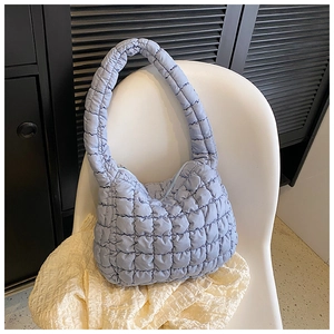 Macro shot of light blue quilted puffer tote bag with stitched diamond pattern details