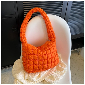 Detail view of the vibrant orange quilted popcorn texture on this soft shoulder tote bag