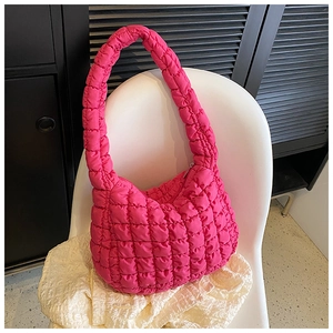 Detail of fuchsia quilted puff tote bag featuring square padding and soft nylon texture