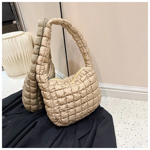 Detailed view of the quilted texture and zipper closure on this cream cloud tote bag