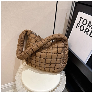 Detail of coffee brown quilted cloud bag featuring square stitching and metal zipper