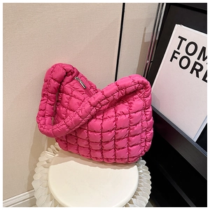 Detailed view of the rose red quilted cloud tote bag with puffy texture on a white chair