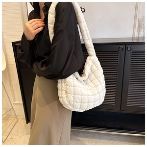 Close-up of white quilted puffy shoulder bag showing soft texture and padded fabric