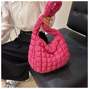 Close-up of bright pink quilted puffer tote bag with diamond stitching texture
